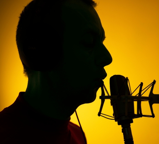 a silhouette of a person singing into a microphone